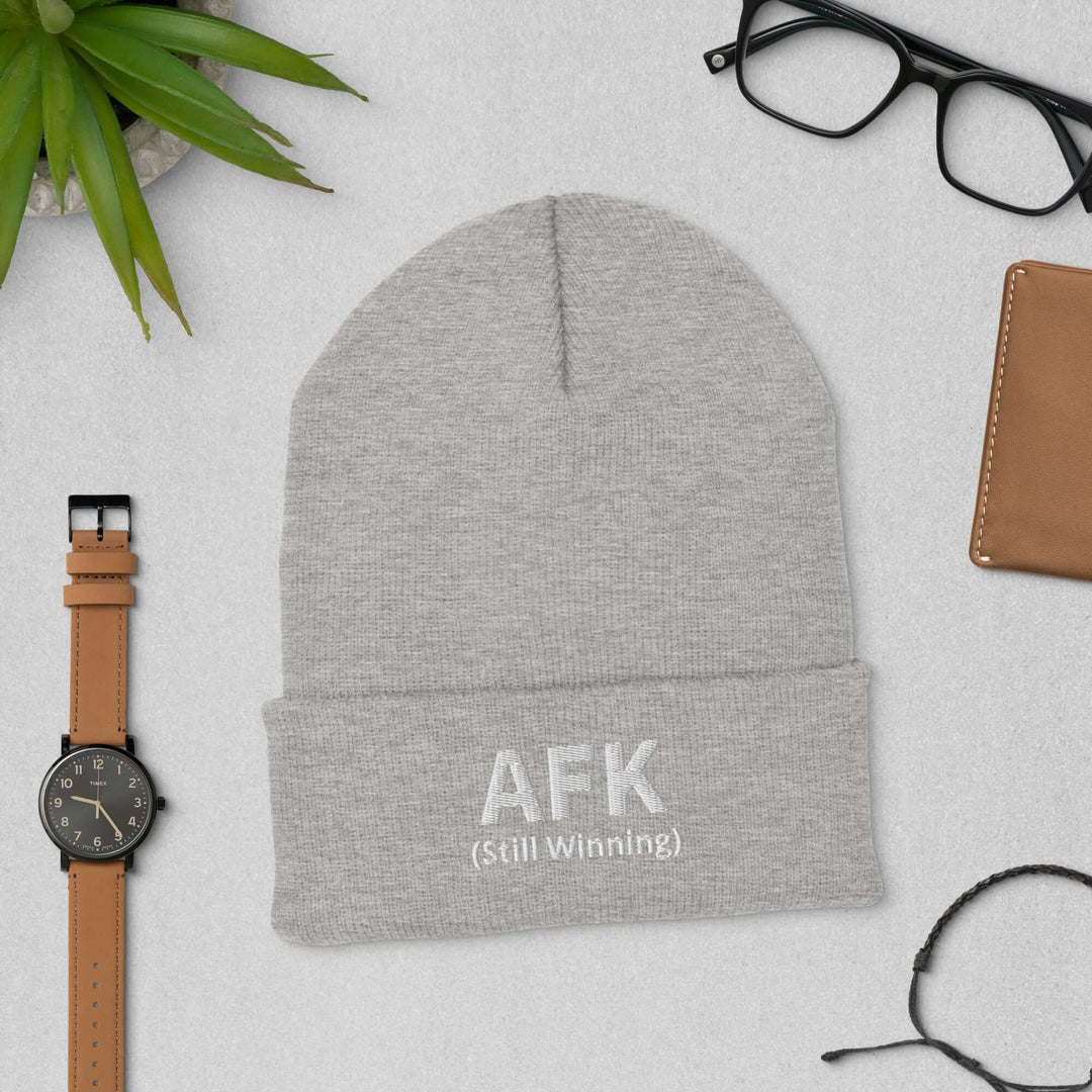 AFK Cuffed Beanie displayed with accessories including a watch and eyeglasses on a flat surface.