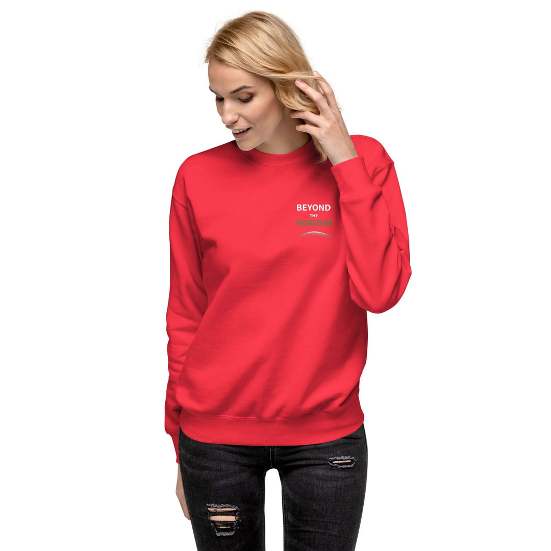 Beyond the Horizon Unisex Premium Sweatshirt in red worn by a smiling woman with stylish long sleeves.